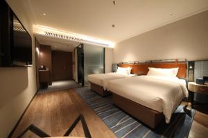 Cette chambre comprend deux lits et une télévision. dans l'établissement City Comfort Inn Foshan Jihua Creative Park, à Foshan