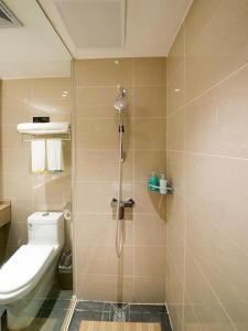 a bathroom with a shower and a toilet at City Comfort Inn Zhaoqing Gaoyao District Government Sports Center in Zhaoqing