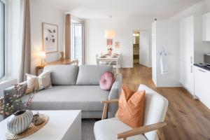a living room with a couch and a table at STAYY The River - contactless check-in in Zürich