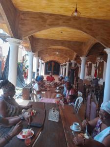 un groupe de personnes assises autour d'une table en bois dans l'établissement Ebora, à Ilhéus