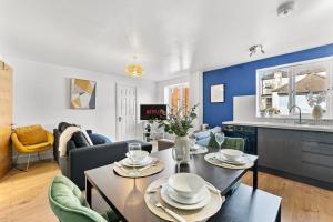 a living room with a table and a kitchen at The Augustine - Stylish City Centre Gem in Kent