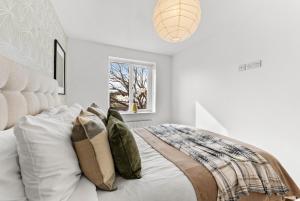 a white bedroom with a bed with pillows at The Augustine - Stylish City Centre Gem in Kent