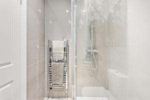 a white bathroom with a shower and a toilet at The Augustine - Stylish City Centre Gem in Kent