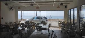 a white truck parked in a room with tables and chairs at Anxhelos Hotel in Himare