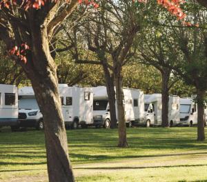 una fila di camper bianchi parcheggiati in un parco di Centro Vacanze - Garden River ad Altidona