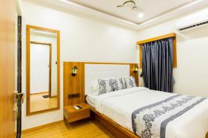 a bedroom with a bed and a mirror at Hotel Village Residency in Mumbai