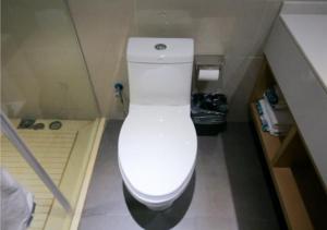 a bathroom with a toilet in a small room at City Comfort Inn Yichang Yiling Bus Station Wanda Plaza in Baiyang