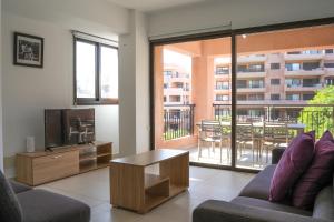 a living room with two couches and a tv at Resitour - Aphrodite Gardens in Paphos City