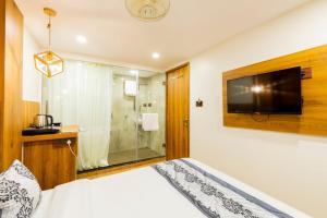 a bedroom with a bed and a television on a wall at Hotel Village Residency in Mumbai