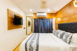 a bedroom with a bed and a tv on a wall at Hotel Village Residency in Mumbai