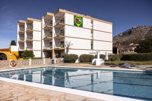 um hotel com piscina em frente a um edifício em RVHotels GR92 em Torroella de Montgrí