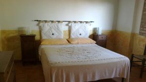 1 dormitorio con 1 cama con colcha blanca en Agriturismo Podere Mulinaccio, en Ribolla