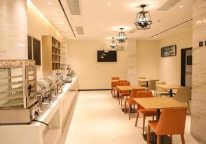 a restaurant with tables and chairs and a cafeteria at City Comfort Inn Jiaxing Tongxiang Tongxing Avenue in Tongxiang