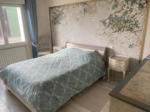 ein Schlafzimmer mit einem Bett und einem Wandgemälde in der Unterkunft Maison 3ch soullans in Soullans