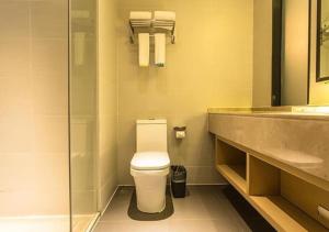 a bathroom with a toilet and a sink at City Comfort Inn Wuzhou Municipal Government Vocational College in Wuzhou