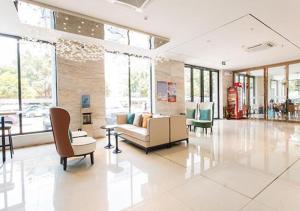 a lobby with a couch and chairs and windows at City Comfort Inn Liuzhou Chengzhong Wanda Haiguan in Liuzhou