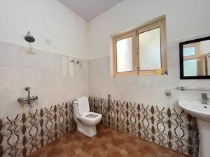 La salle de bains est pourvue de toilettes, d'un lavabo et d'une fenêtre. dans l'établissement Safarnama Homestay Leh - Best Rooms in Leh with Parking, à Leh