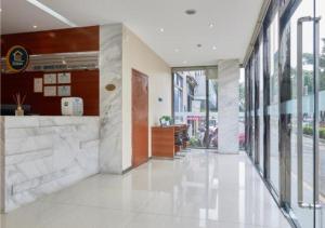 a hallway of a building with white tile floors and windows at City Comfort Inn Liuzhou Baisha Bus Station Shengli Barbecue City in Liuzhou