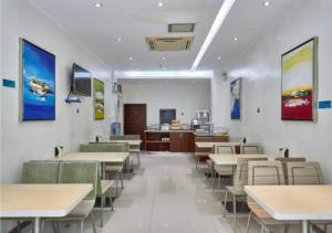 a dining room with tables and chairs and a kitchen at City Comfort Inn Liuzhou Baisha Bus Station Shengli Barbecue City in Liuzhou