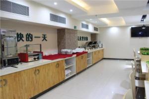 a kitchen with wooden cabinets and a red counter top at City Comfort Inn Wuzhou South High Speed Railway Station in Cangwu