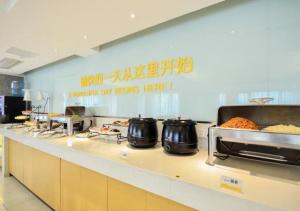 uma cozinha com panelas e frigideiras num balcão em City Comfort Inn Jingzhou Wanda Plaza em Caoshi