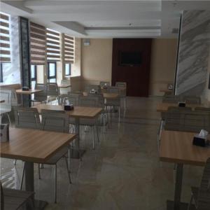 une salle de classe vide avec des tables et des chaises dans un bâtiment dans l'établissement City Comfort Inn Maoming High Speed Railway Station, à Maoming
