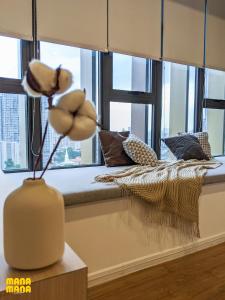 a vase with a flower on a table in front of a window at Ceylonz Suites KLCC Rooftop Infinity Pool KL Tower View in Kuala Lumpur