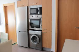 uma cozinha com uma máquina de lavar roupa e um micro-ondas em M515 Apartamento Las Dunas Oliva Nova em Oliva