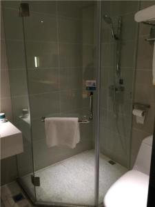 y baño con ducha y puerta de cristal. en City Comfort Inn Changsha Jingwanzi Desiqin Plaza, en Yangtianhu