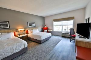 a hotel room with two beds and a flat screen tv at Hilton Garden Inn Savannah Historic District in Savannah