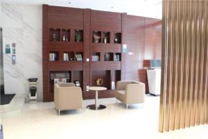 a lobby with two chairs and a table and a fireplace at City Comfort Inn Liuzhou Intime City Ma'anshan Music Fountain River View in Liuzhou