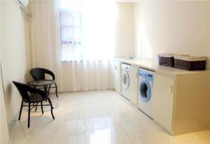 a laundry room with a washer and a table and chairs at City Comfort Inn Liuzhou Intime City Ma'anshan Music Fountain River View in Liuzhou