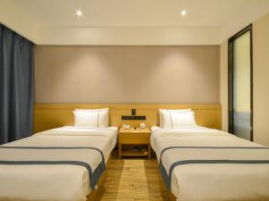 Habitación de hotel con 2 camas y mesa en City Comfort Inn Suizhou Railway Station, en Suizhou