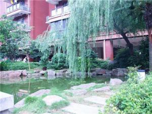 einen Garten mit einem Teich vor einem Gebäude in der Unterkunft City Comfort Inn Huangshi Wanda Plaza Huashan Road in Huangshi