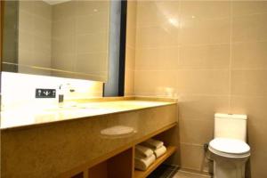 W łazience znajduje się umywalka, toaleta i lustro. w obiekcie City Comfort Inn Jinan Railway Station Daming Lake w mieście Jinan