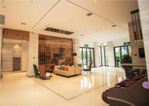 a lobby with a couch and chairs in a building at City Comfort Inn Luoyang Lijingmen Metro Station in Luoyang
