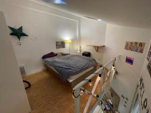 - une petite chambre avec un lit et un escalier dans l'établissement Maisonnette en duplex 25 M2, Pantin porte de Paris, à Pantin