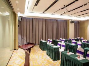 una sala de conferencias con mesas verdes y sillas moradas en Echarm Hotel Huangshi Yingbin Avenue en Huangshi