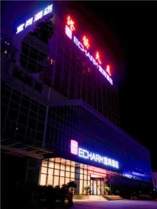 un edificio con luces rojas y azules encima en Echarm Hotel Huangshi Yingbin Avenue en Huangshi