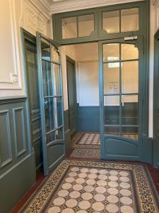 un pasillo vacío con una puerta azul y una alfombra en Maisonnette en duplex 25 M2, Pantin porte de Paris, en Pantin