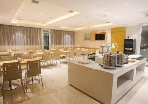 uma grande sala com mesas e cadeiras e uma cafetaria em City Comfort Inn Ji'an Railway Station Jinggangshan University 