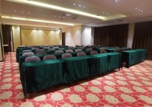 uma sala de conferências com mesas e cadeiras verdes em City Comfort Inn Ji'an Railway Station Jinggangshan University 