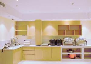a kitchen with yellow and white counters and shelves at City Comfort Inn Shiyan Beijing Road in Maojianqu