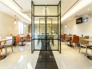 un restaurante con puertas de cristal, mesas y sillas en City Comfort Inn Nanning Wuming en Wuming