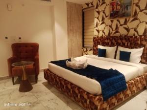 a bedroom with a large bed and a chair at Hotel 7 Days Inn Dharamshala in Dharamshala