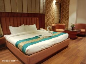 a bedroom with a large bed with a swan on it at Hotel 7 Days Inn Dharamshala in Dharamshala