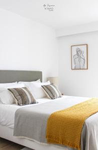 - une chambre avec un grand lit et une couverture jaune dans l'établissement Nomad Houses - Ap Tereno, à Beja