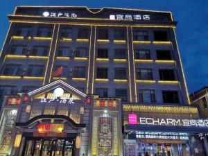 wysoki budynek z oświetleniem na górze w obiekcie Echarm Hotel Changchun Jiutai District Government Railway Station 