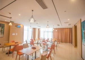 a restaurant with tables and chairs in a room at City Comfort Inn Xuancheng Wanda Qinglv Guoji in Xuanzhou