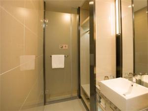 a bathroom with a sink and a glass shower at Echarm Hotel Changchun Jiutai District Government Railway Station 